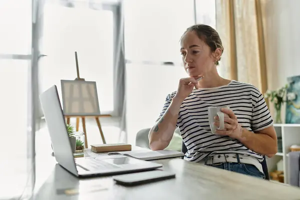 A woman with vitiligo thoughtfully enjoys her drink while working from home. — Stock Photo