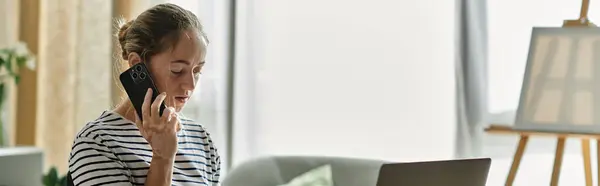 A woman with vitiligo speaks intently on her phone while sitting in a cozy living room. — Stock Photo