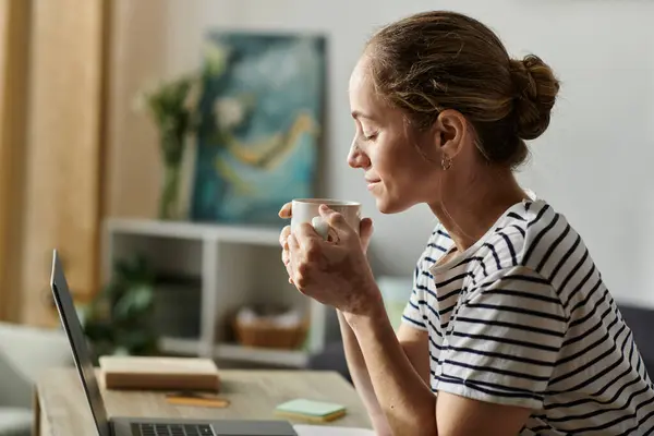 A woman with vitiligo relaxes while sipping a warm beverage in her cozy living space. — Stock Photo