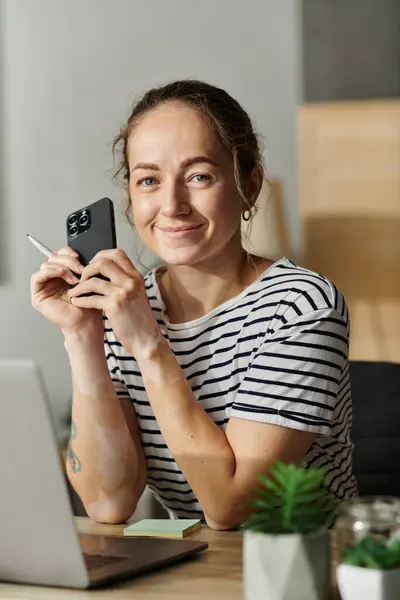 A beautiful woman with vitiligo smiles while holding her smartphone. — Stock Photo