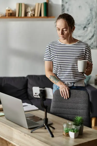 A beautiful woman with vitiligo stands thoughtfully holding a coffee cup. — Stock Photo