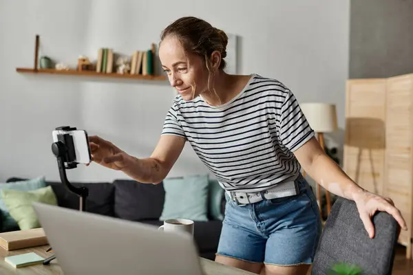 A woman with vitiligo smiles while setting up her camera for a new project. — Stock Photo