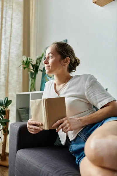A woman with vitiligo enjoys a quiet moment while reading in soft, natural light. — Stock Photo