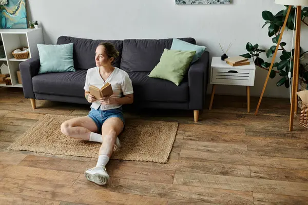 Eine Frau mit Vitiligo genießt ein Buch, während sie auf dem Boden sitzt. — Stockfoto