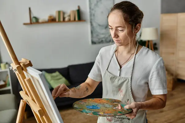 A woman with vitiligo focuses intently on her colorful canvas. — Stock Photo