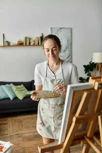 A joyful woman with vitiligo passionately paints on a canvas in her creative space. — Stock Photo