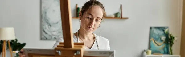 A young artist focused on her canvas, expressing creativity and beauty. — Stock Photo