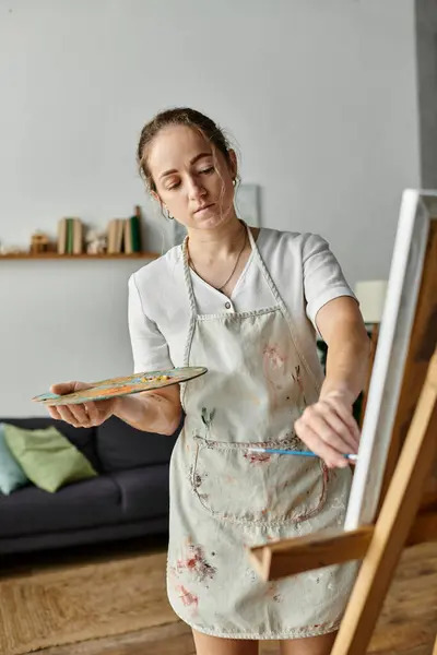 A talented woman expresses herself through vibrant painting in a stylish studio. — Stock Photo