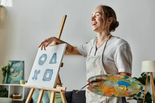 A talented woman joyfully shares her artistic passion while painting. — Stock Photo