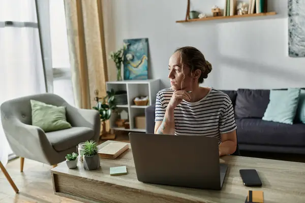 A woman admires her workspace as sunlight filters through the window. — Stock Photo