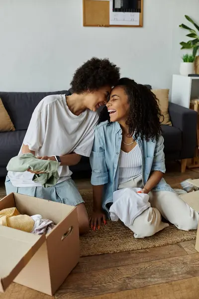 A couple joyfully transforms their clothes together in a sunny space. — Stock Photo