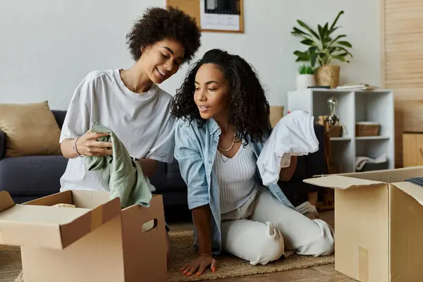 LGBT couple joyfully transforms their clothes in a cozy living space. — Stock Photo