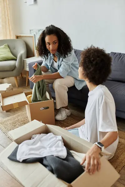 Um casal alegremente transforma roupas velhas em novas peças juntas. — Fotografia de Stock