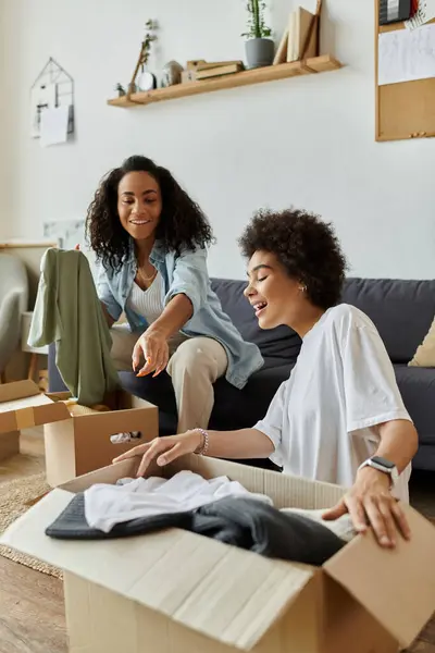 An LGBT couple joyfully transforms old clothes into new styles. — Stock Photo