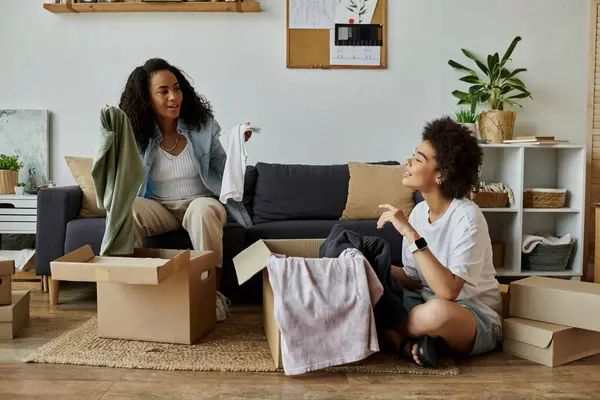 A joyful LGBT couple transforms old clothes together, fostering creativity and love. — Stock Photo