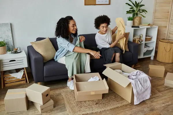 A couple enjoys transforming old clothes into new designs at home. — Stock Photo