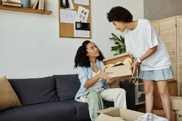 LGBT couple joyfully transforms their clothes together in a warm setting. — Stock Photo