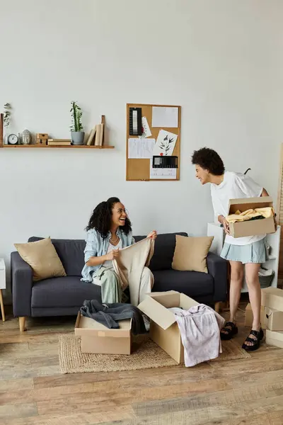 A joyful couple creatively upcycling their clothes in a cozy living room. — Stock Photo
