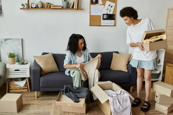 A loving couple sorts through clothing to create something new and stylish. — Stock Photo