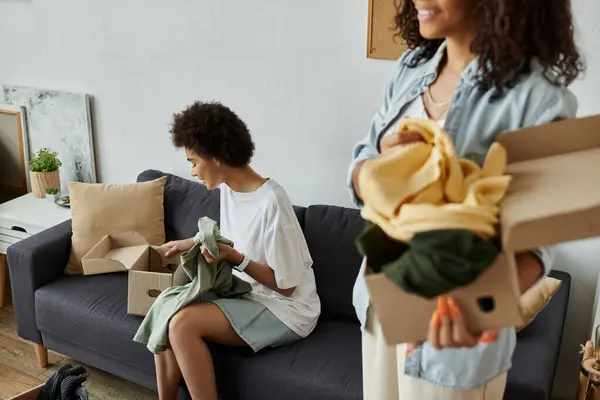 An LGBT couple joyfully transforms old clothes into new treasures together. — Stock Photo