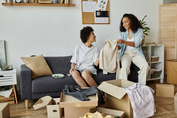 A couple joyfully transforms old clothes into something new in their stylish living room. — Stock Photo