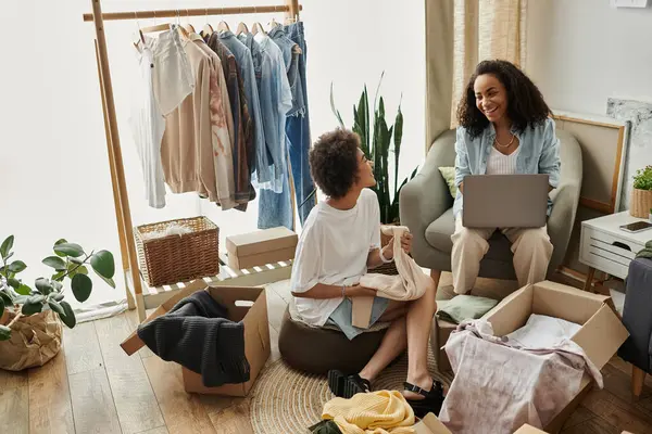 Couple enjoys upcycling clothes together while sitting in a sunny, vibrant room. — Stock Photo