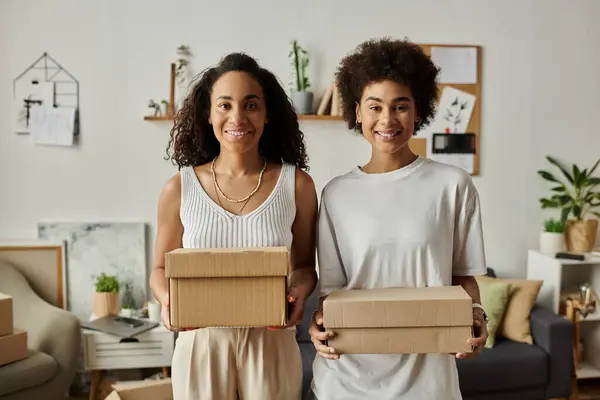 Couple joyfully reimagines clothing while holding up boxes. — Stock Photo