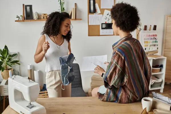 A couple happily designs and transforms their clothing in a warm workshop. — Stock Photo