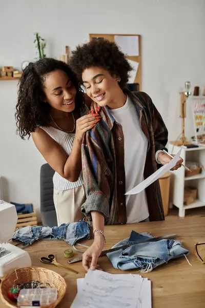 Couple joyfully transforms old clothes into new pieces in their creative workspace. — Stock Photo