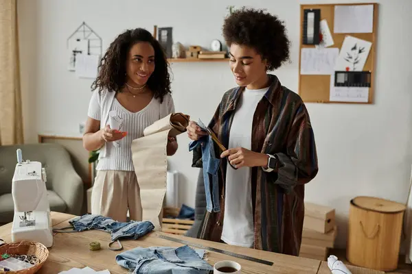 Two friends joyfully transform and personalize their old garments. — Stock Photo