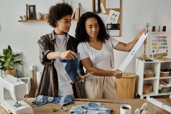 An LGBT couple joyfully repurposes old clothing in a cozy studio. — Stock Photo