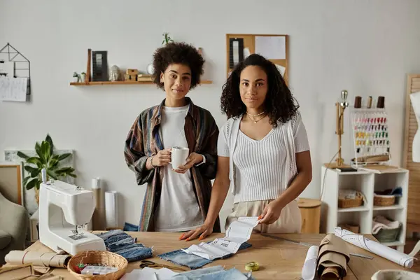 Pareja transforma la ropa vieja en nuevas creaciones con estilo en su espacio de trabajo. - foto de stock