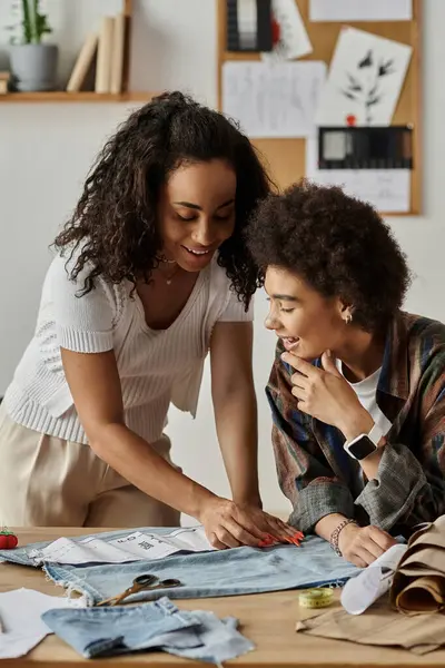 A couple joyfully redesigns their clothing in a vibrant workspace. — Stock Photo