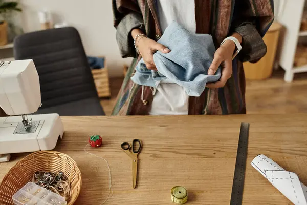 A woman creatively transforms old garments into new fashion. — Stock Photo