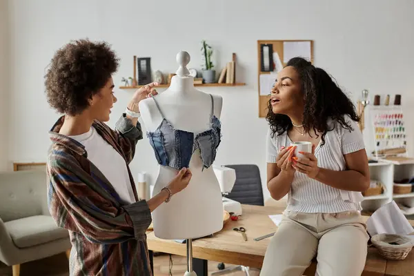 Duas pessoas transformam roupas alegremente em um ambiente criativo. — Fotografia de Stock