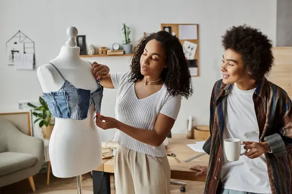 A couple joyfully transforms old garments into new fashion pieces together. — Stock Photo
