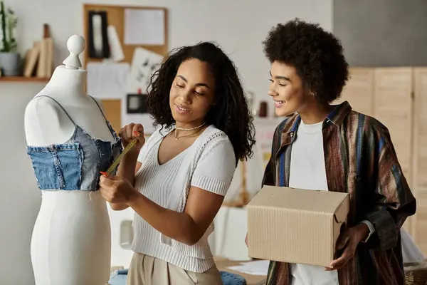 Couple measuring and transforming clothes with joy and creativity in their workspace. — Stock Photo