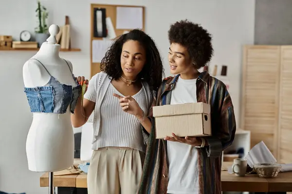 Couple joyfully transforms clothing in their cozy workspace. — Stock Photo