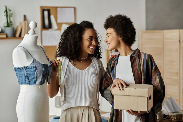 Um casal alegre transforma roupas antigas em novos projetos elegantes. — Fotografia de Stock