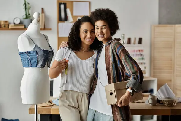 Un couple transforme joyeusement leurs vêtements dans un espace de travail vibrant. — Stock Photo