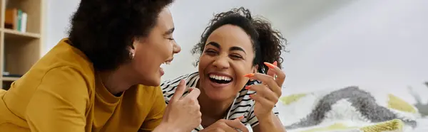 Two women share laughter and love while relaxing together at home. — Stock Photo