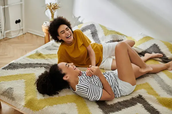 A loving couple shares laughter and playful moments on a comfortable rug. — Stock Photo