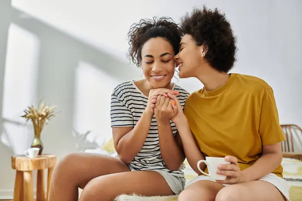 A loving couple enjoys a tender moment at home, sharing laughter and affection over tea. — Stock Photo