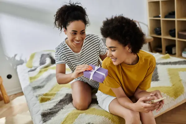 A couple shares a heartfelt moment while exchanging a thoughtful gift indoors. — Stock Photo
