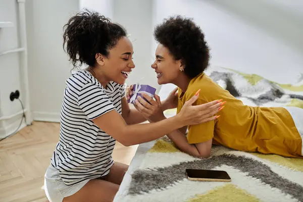 Due donne condividono risate e tenerezza in uno spazio caldo e invitante. — Foto stock