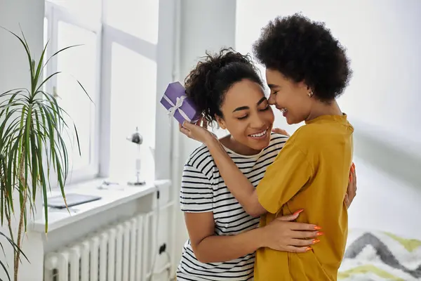 A happy couple shares an intimate embrace while celebrating in their bright home. — Stock Photo