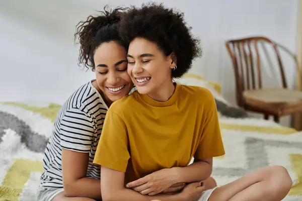 Two women share a warm embrace, radiating love and happiness in their shared space. — Stock Photo