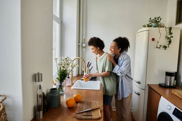 Ein liebendes Paar teilt einen zarten Moment beim gemeinsamen Geschirrspülen. — Stockfoto