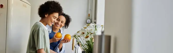 Couple smiles lovingly while preparing fresh oranges together at home. — Stock Photo