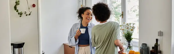 Couple partage un sourire chaleureux tout en dégustant un café ensemble dans leur maison confortable. — Stock Photo